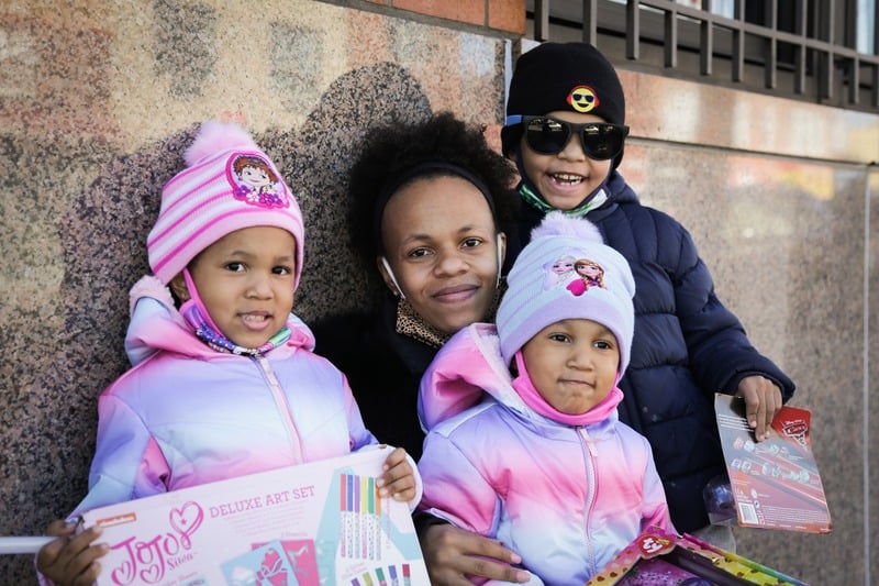 A family smiling together with children’s gifts
